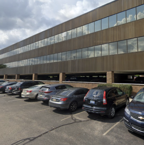 View outside of MBPIA building from the parking lot with cars parked outside